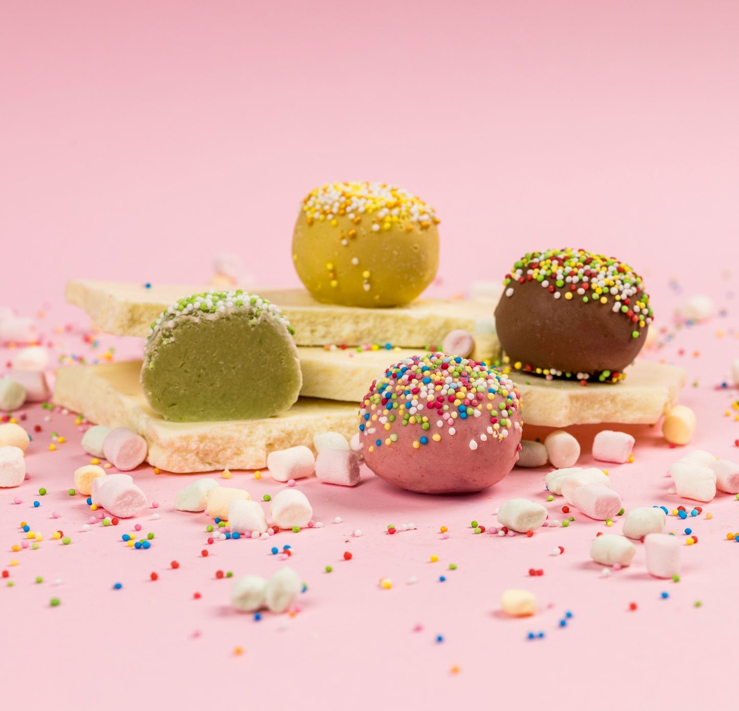 Négy féle marcipán kompozícióban, csokoládé táblán topping szórással. Four types of marzipan in a composition, with chocolate bars and sprinkled toppings. Vier Arten von Marzipan in einer Komposition, mit Schokoladentafeln und bestreuten Toppings.