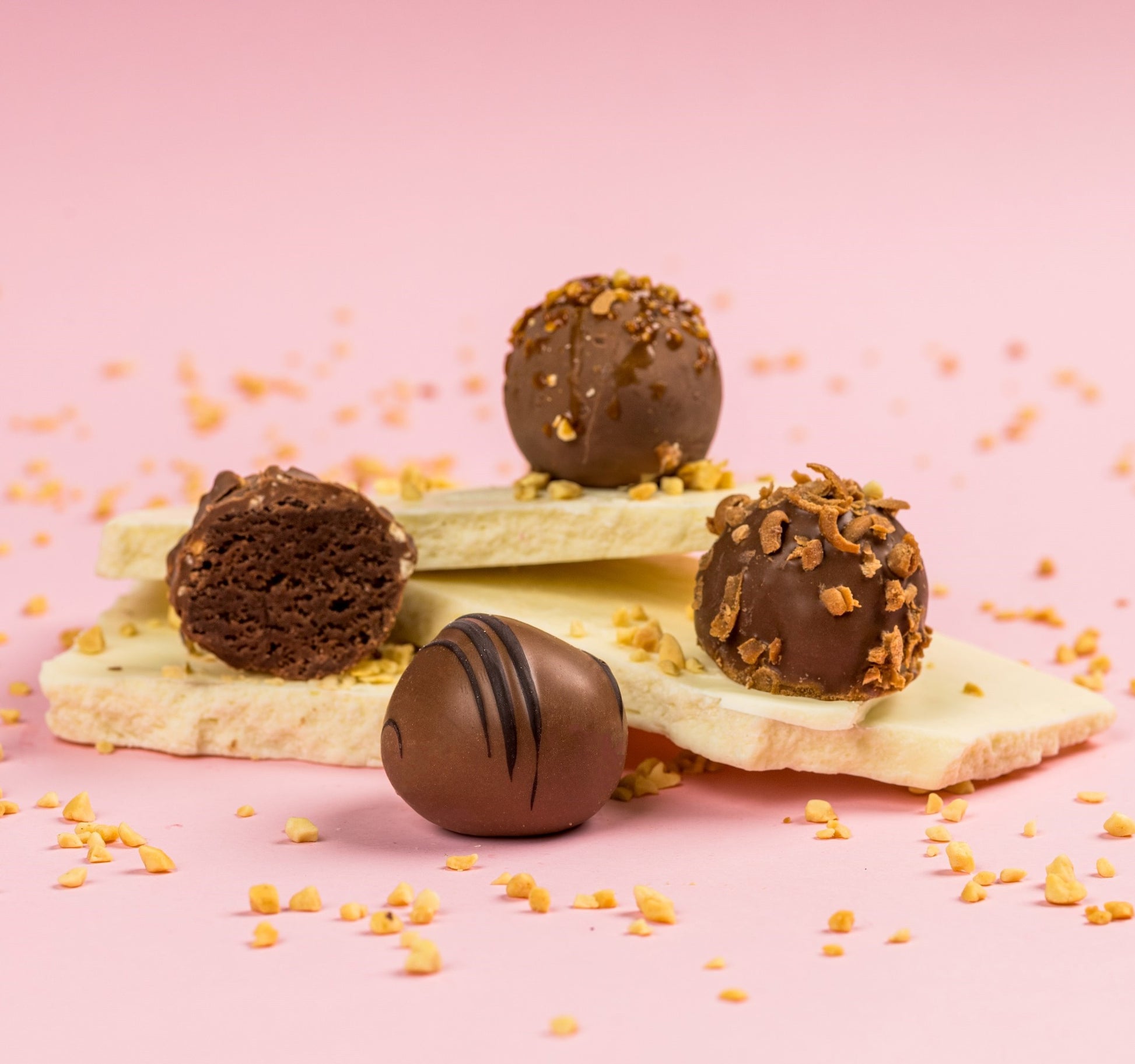 Négy féle marcipán kompozícióban, csokoládé táblán topping szórással. Four types of marzipan in a composition, with chocolate bars and sprinkled toppings. Vier Arten von Marzipan in einer Komposition, mit Schokoladentafeln und bestreuten Toppings.