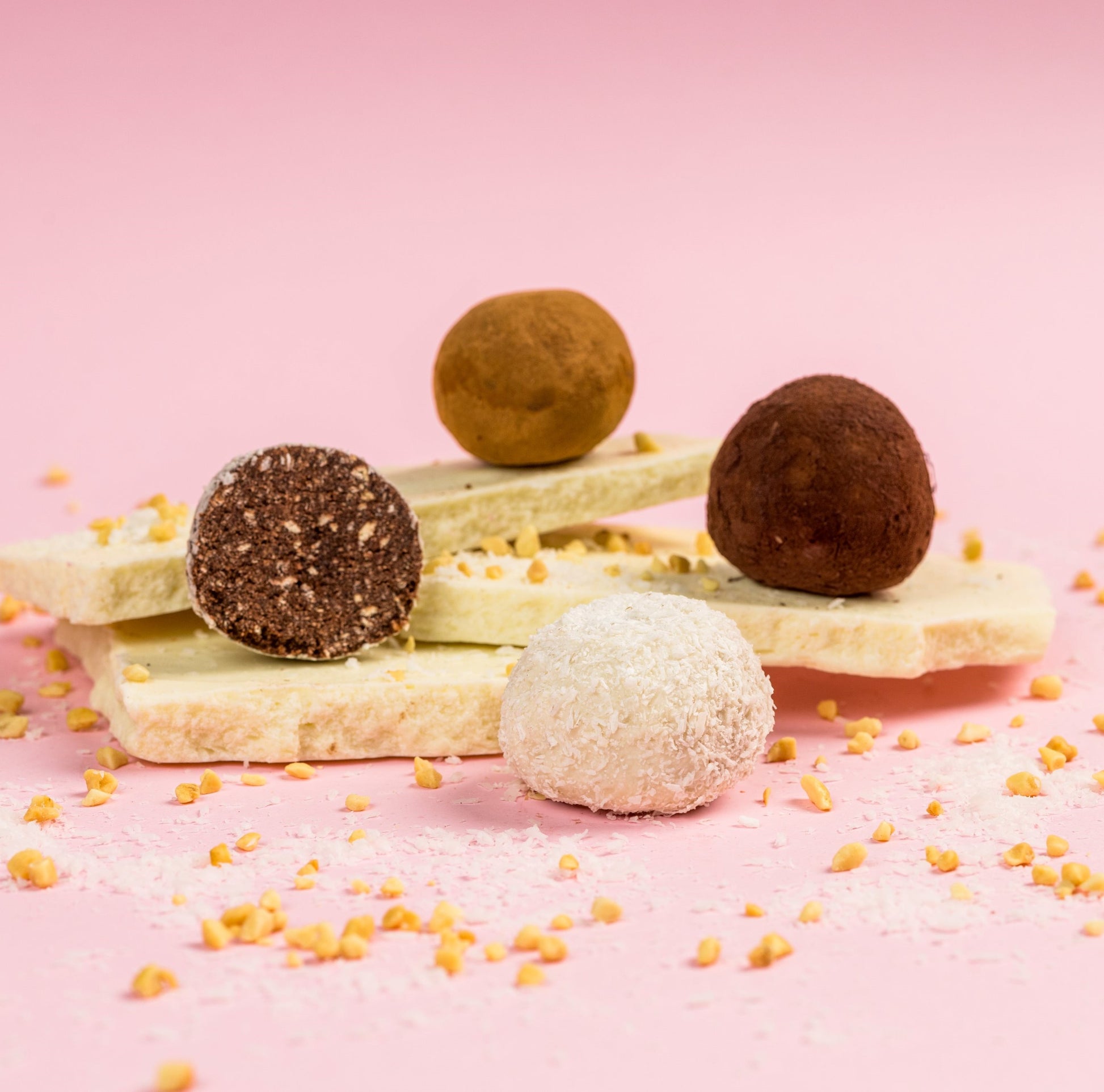 Négy féle marcipán kompozícióban, csokoládé táblán topping szórással. Four types of marzipan in a composition, with chocolate bars and sprinkled toppings. Vier Arten von Marzipan in einer Komposition, mit Schokoladentafeln und bestreuten Toppings.